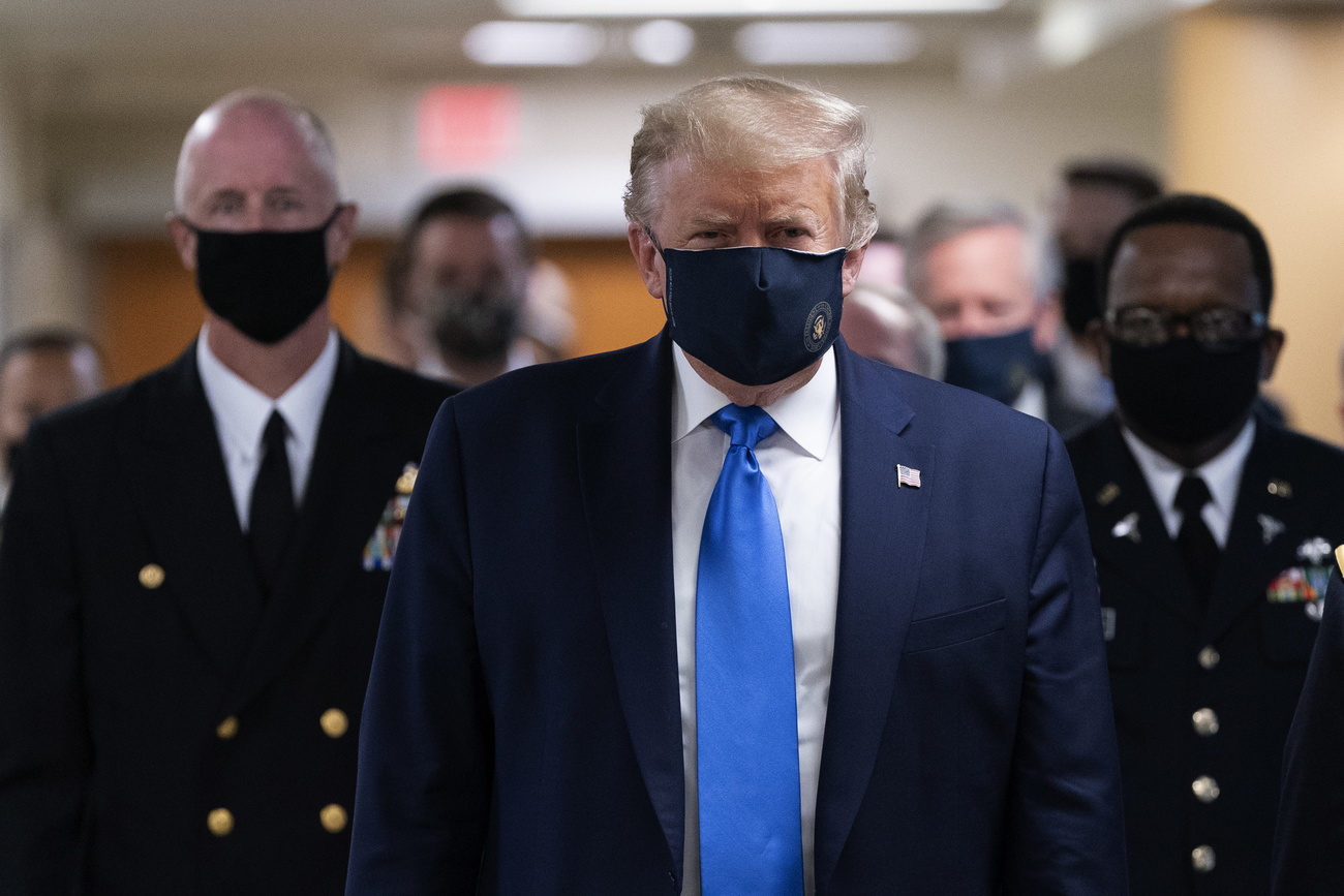 Un Trump inedito con tanto di mascherina e capelli non più tinti di biondo-rossiccio.