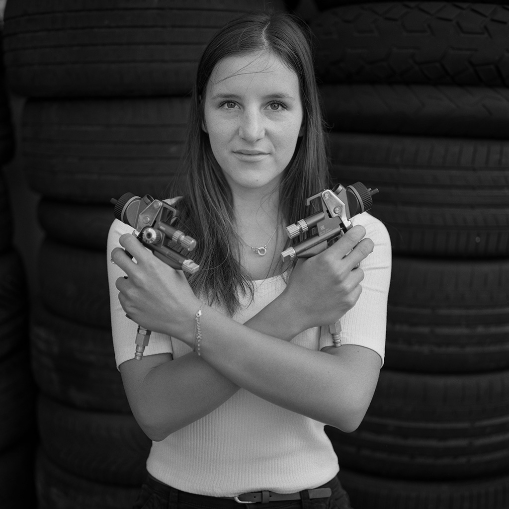 Aurélie Fawer con los brazos cruzados sobre el pecho y pistolas para pintar en cada mano