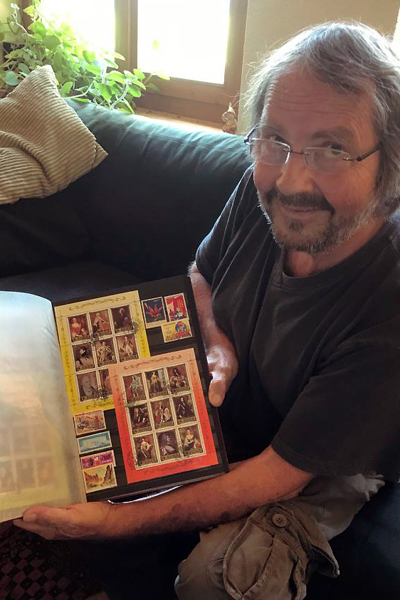 Hombre muestra álbum de estampillas