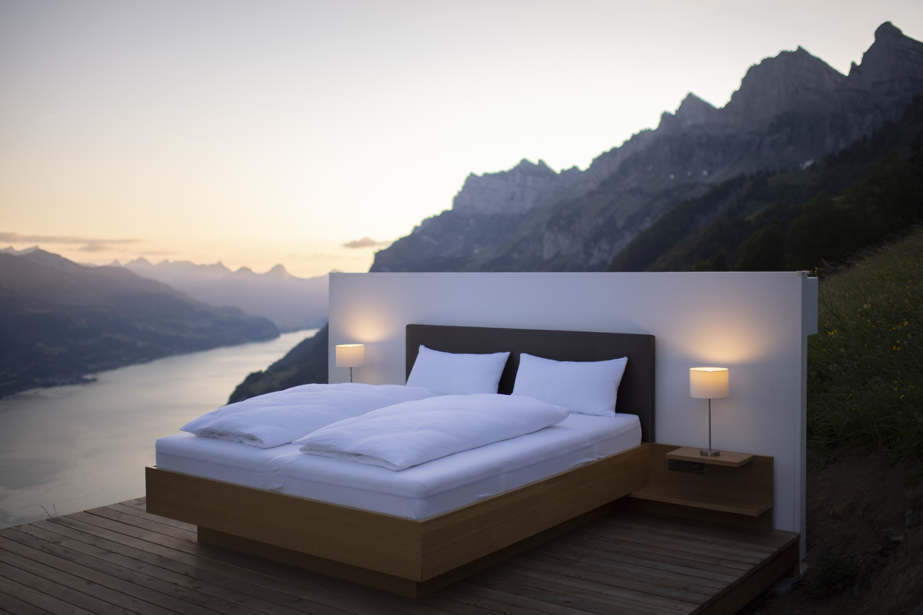Hotel bed beside lake and mountain