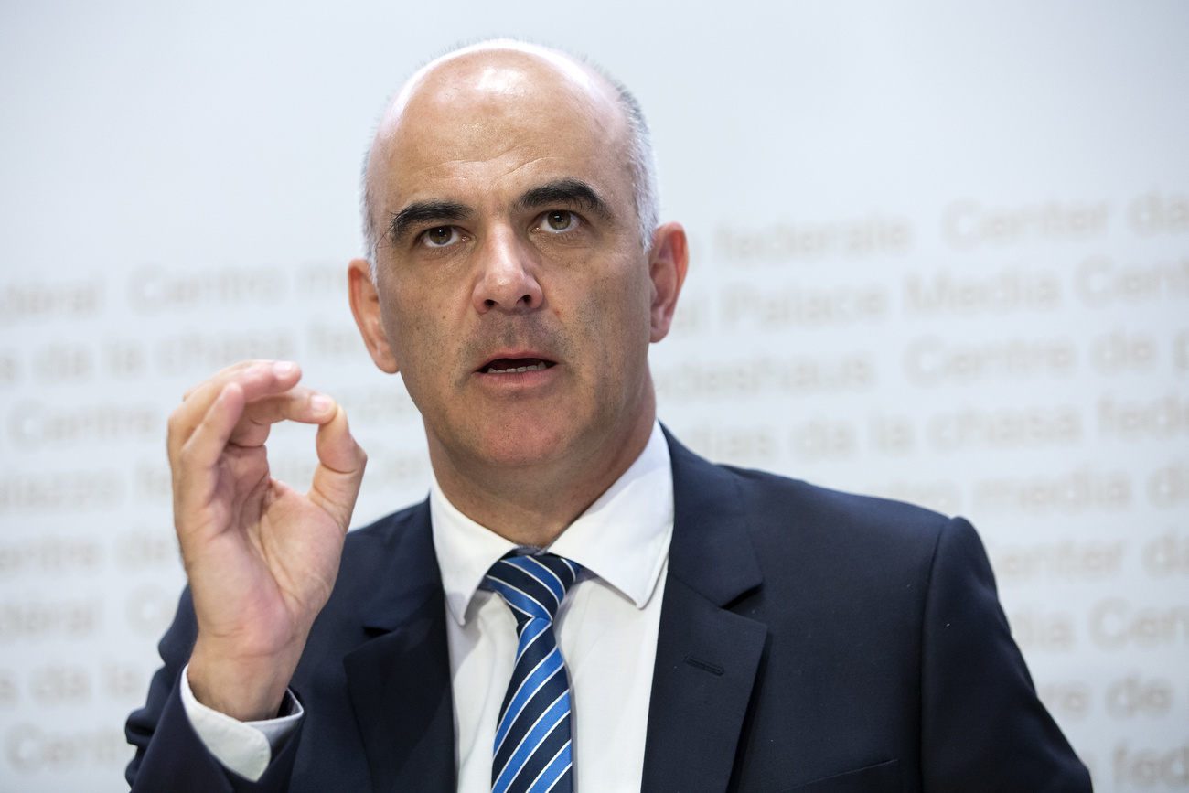 Mezzobusto di un uomo in abito formale che parla facendo un gesto; sul fondo, scritta Consiglio federale