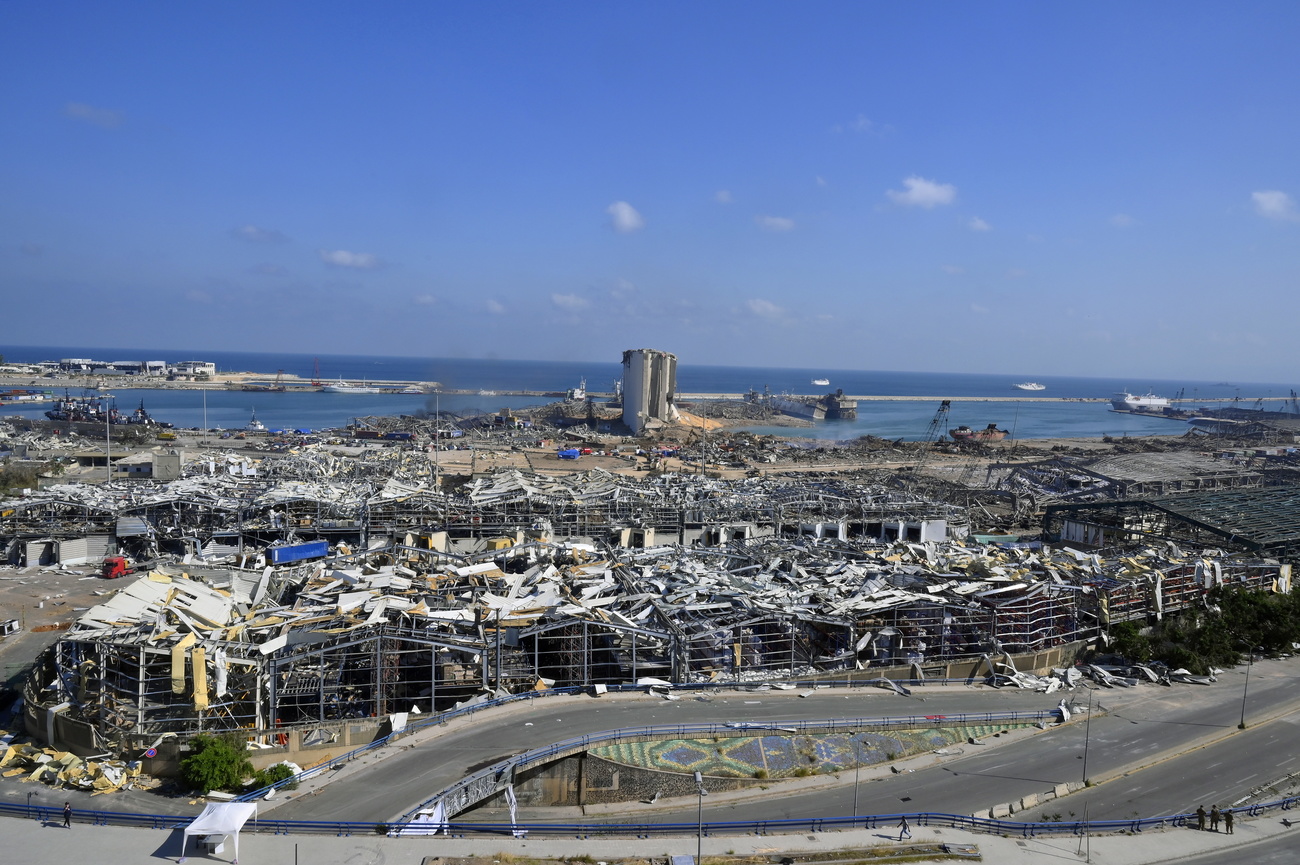 Quartiere di case e magazzini lungo un golfo di mare quasi completamente raso al suolo.