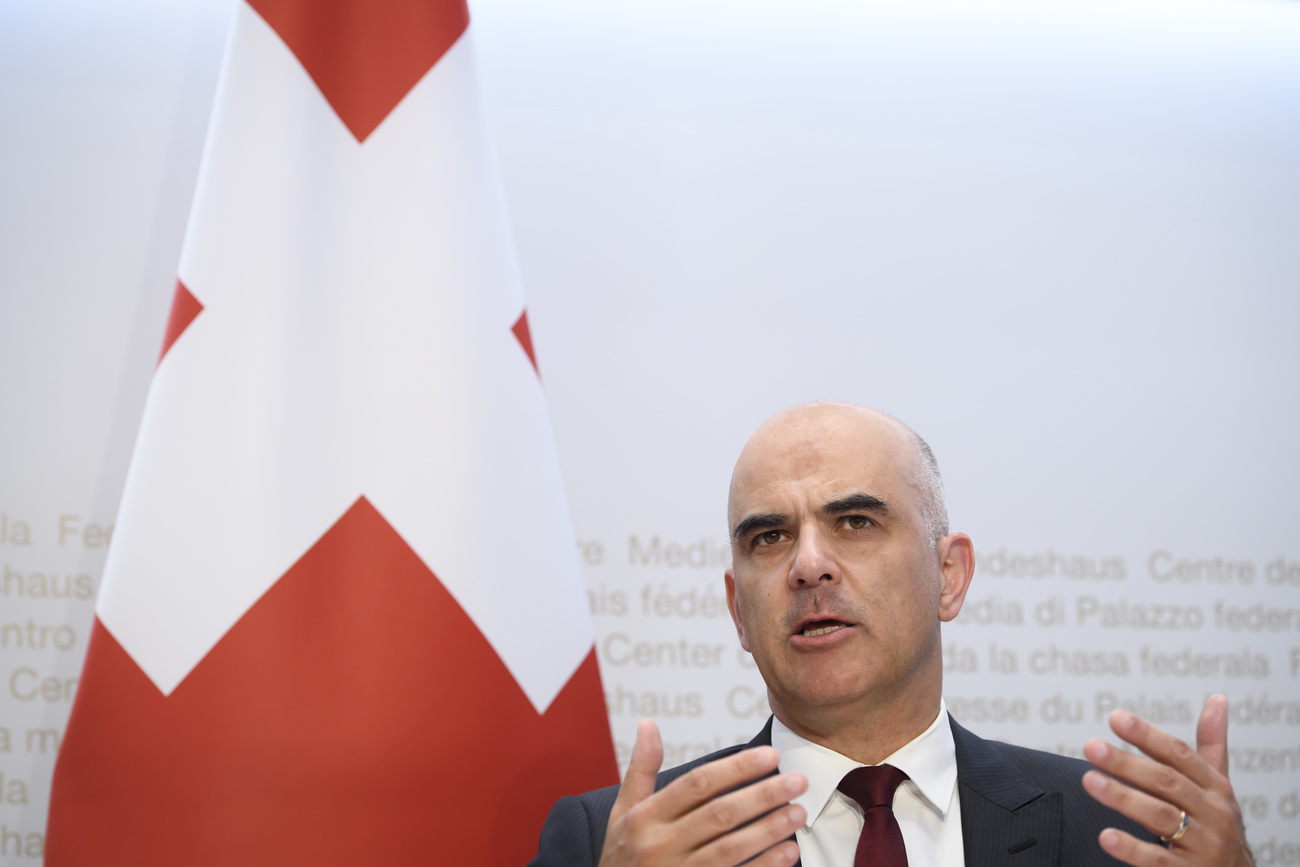 Primo piano di Alain Berset con dietro una bandiera svizzera.