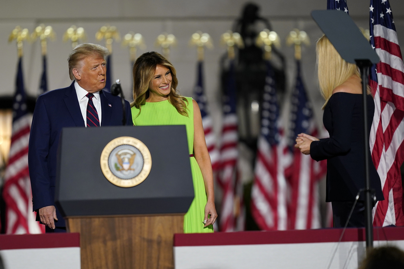 Donald e Melania Trump si avvicinano al puplito presidenziale mentre sorridono a Ivanka, di lato e di schiena