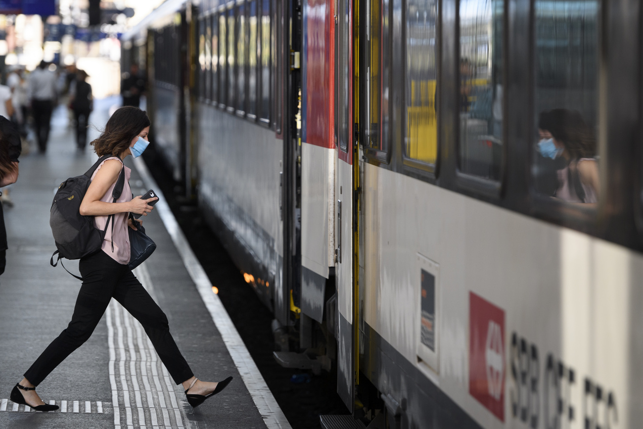 Person wearing mask steps onto train