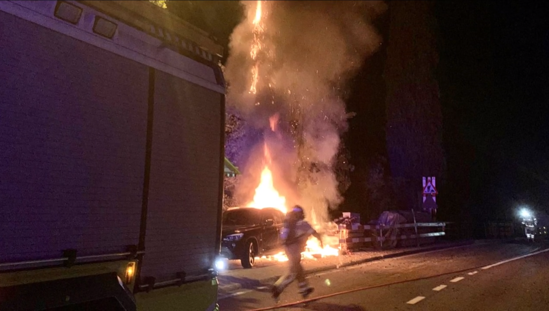 Pompiere scende di corsa da autobotte e va verso un auto in fiamme per spegnere incendio