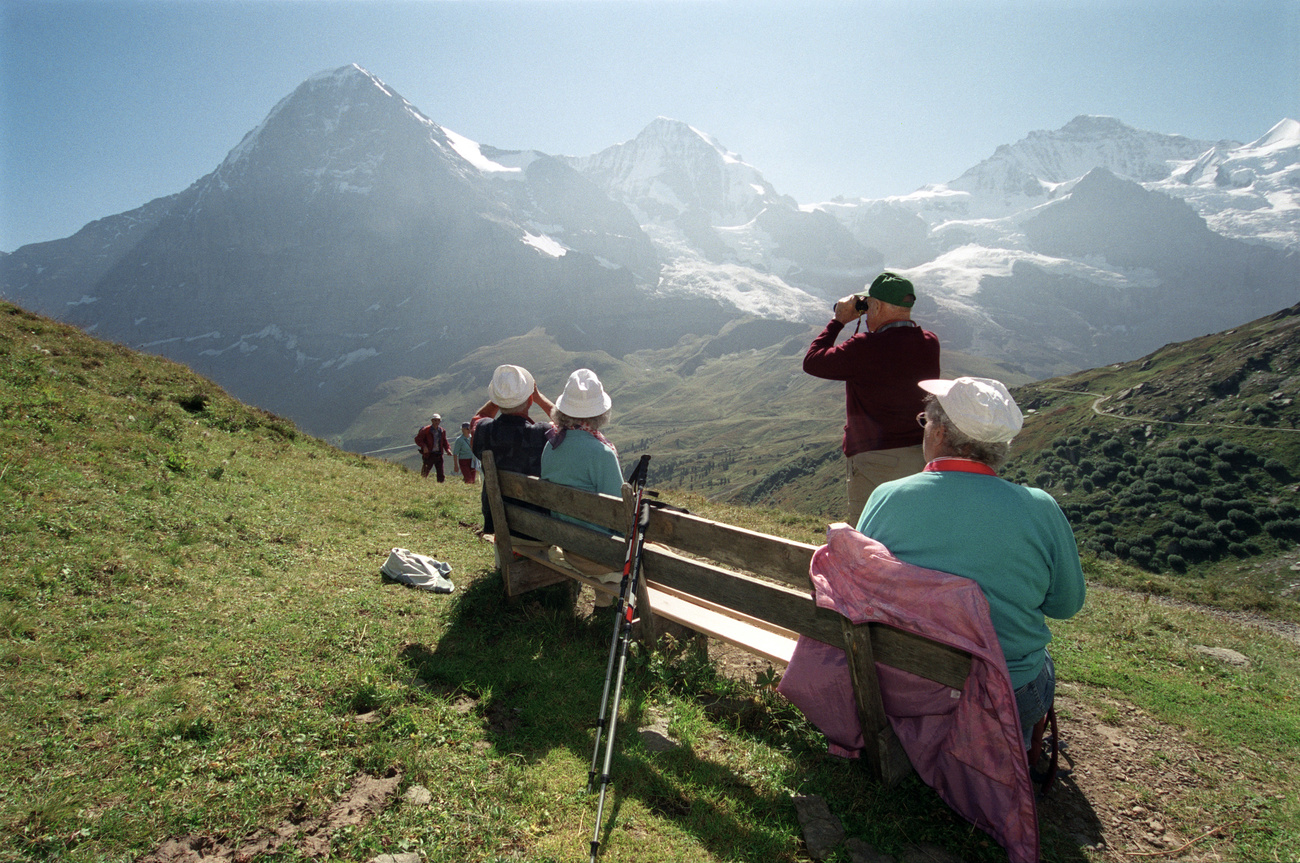persone guardano con un cannnocchiale una montagna