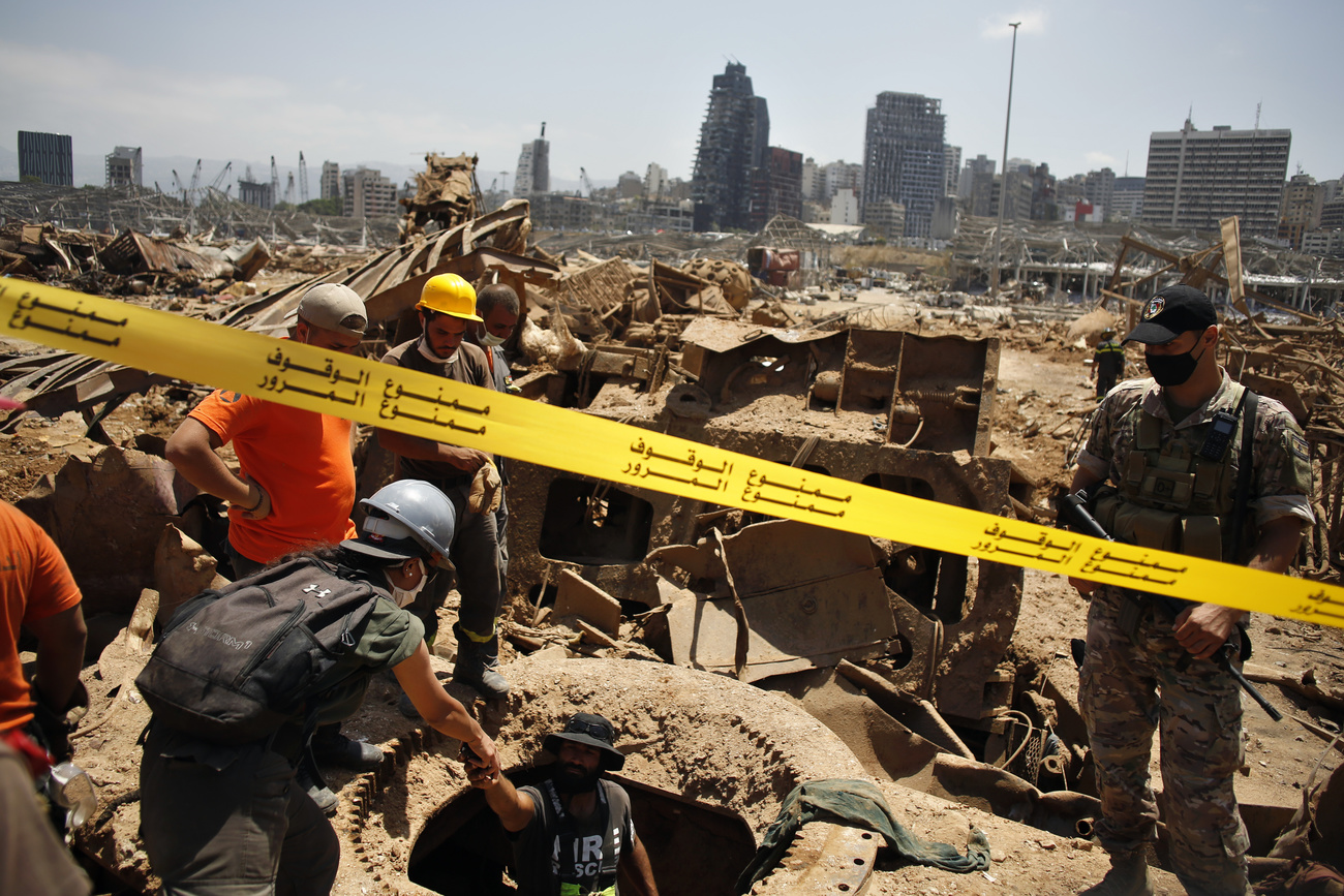 Soccorritori lavorano su un terreno di edifici completamente distrutti e mobilio e materiale divelti