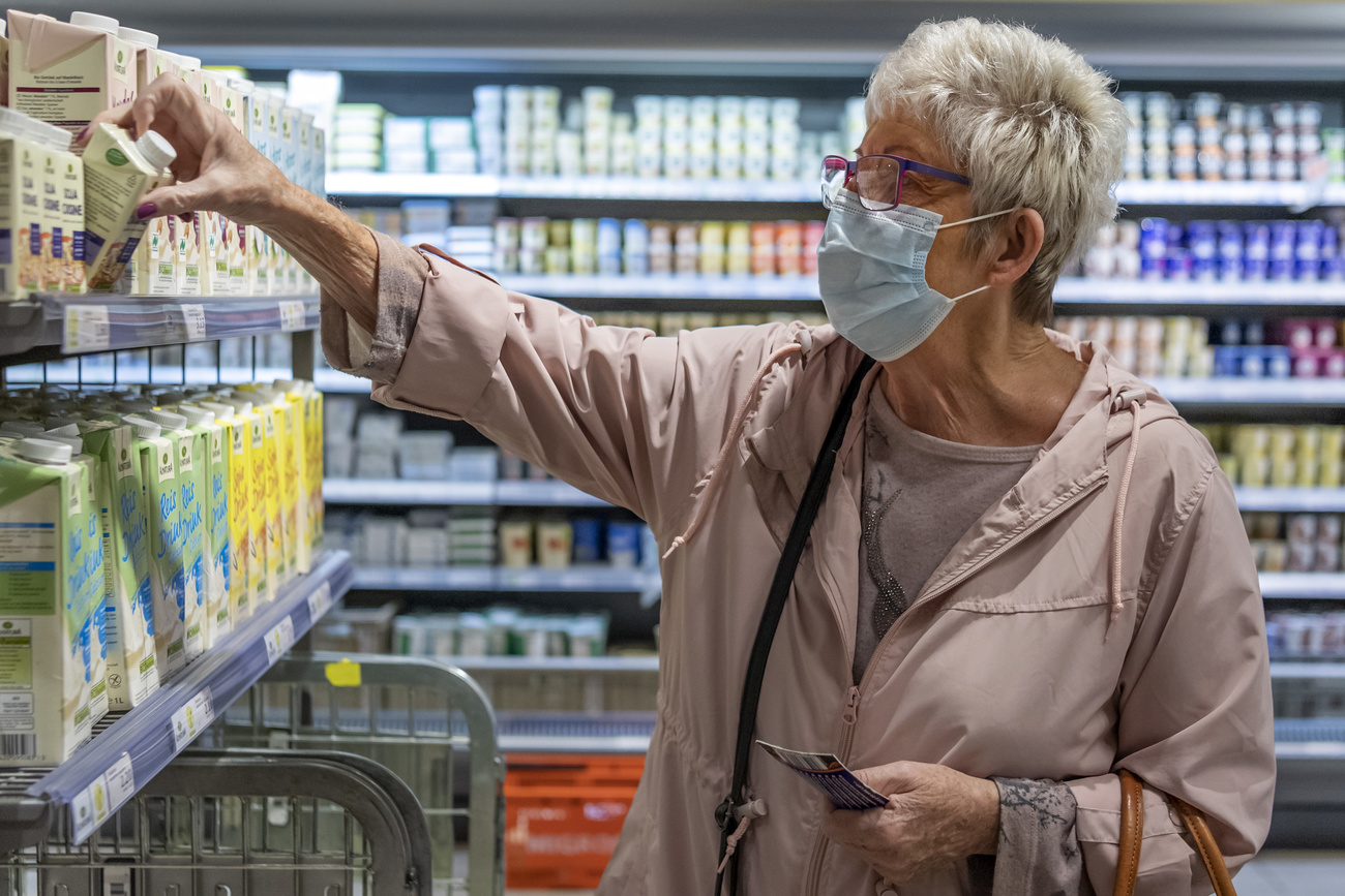 Maskentragende Frau im Coop/Migros