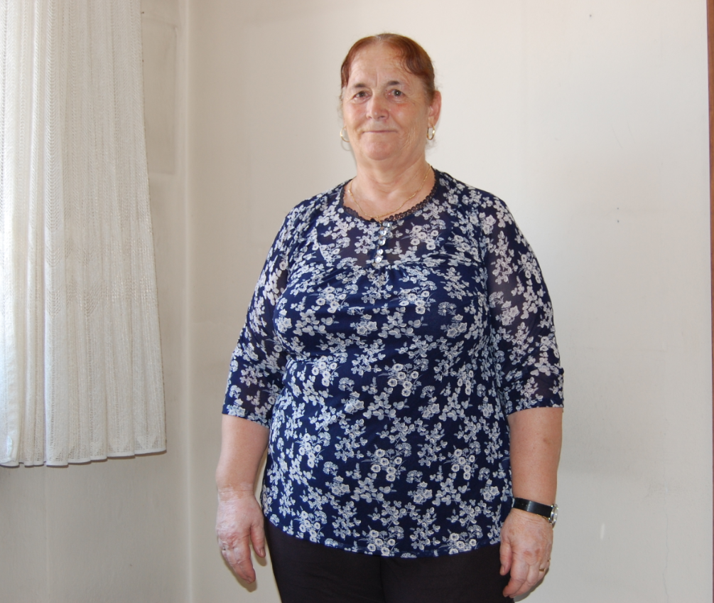 Une femme pose dans un appartement devant une fenêtre