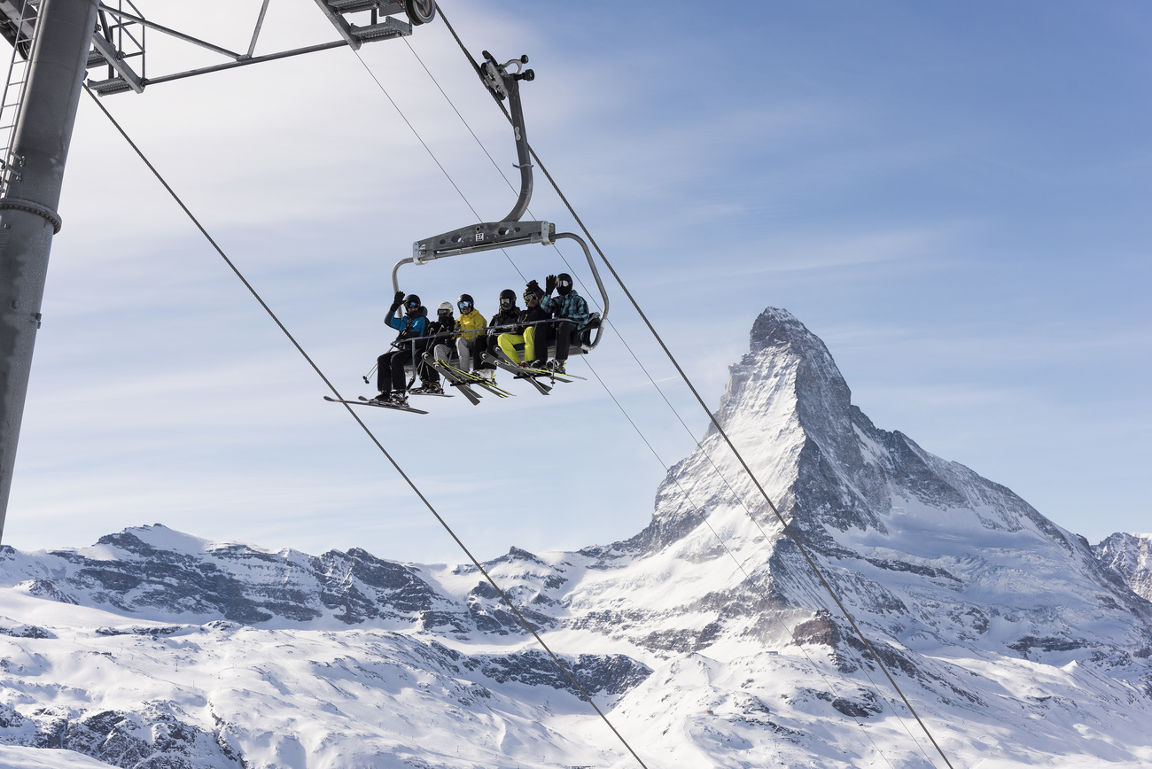 Skiers on ski lift with Matterhorn backdrop