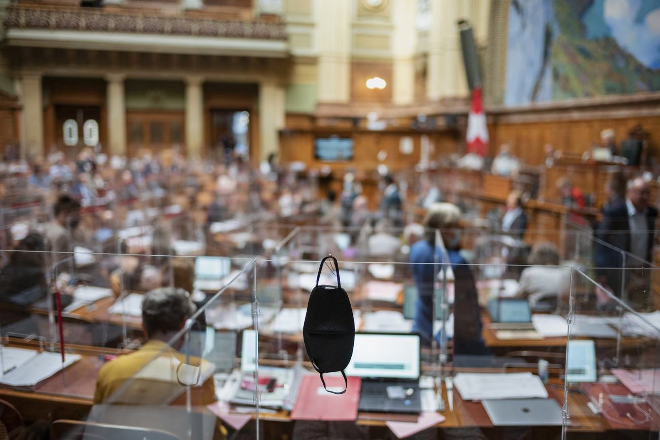 Un masque de protection accroché à une paroi de plexiglas au Parlement, pendant la session d automne.