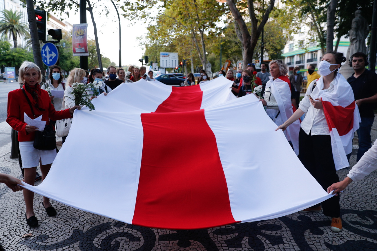 Women holding a giant Belarussian flag