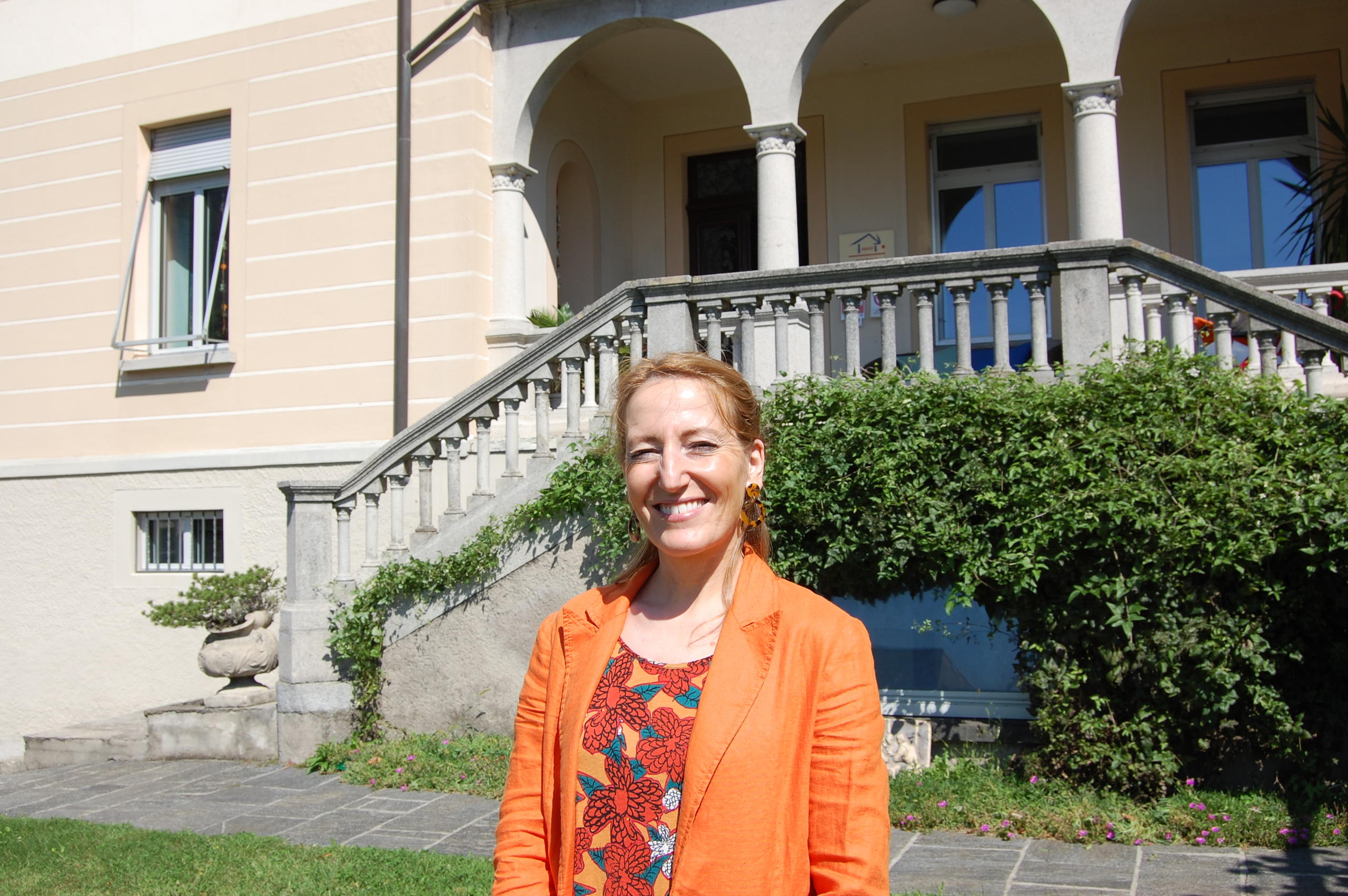 una donna sorridente in piedi in un giardino