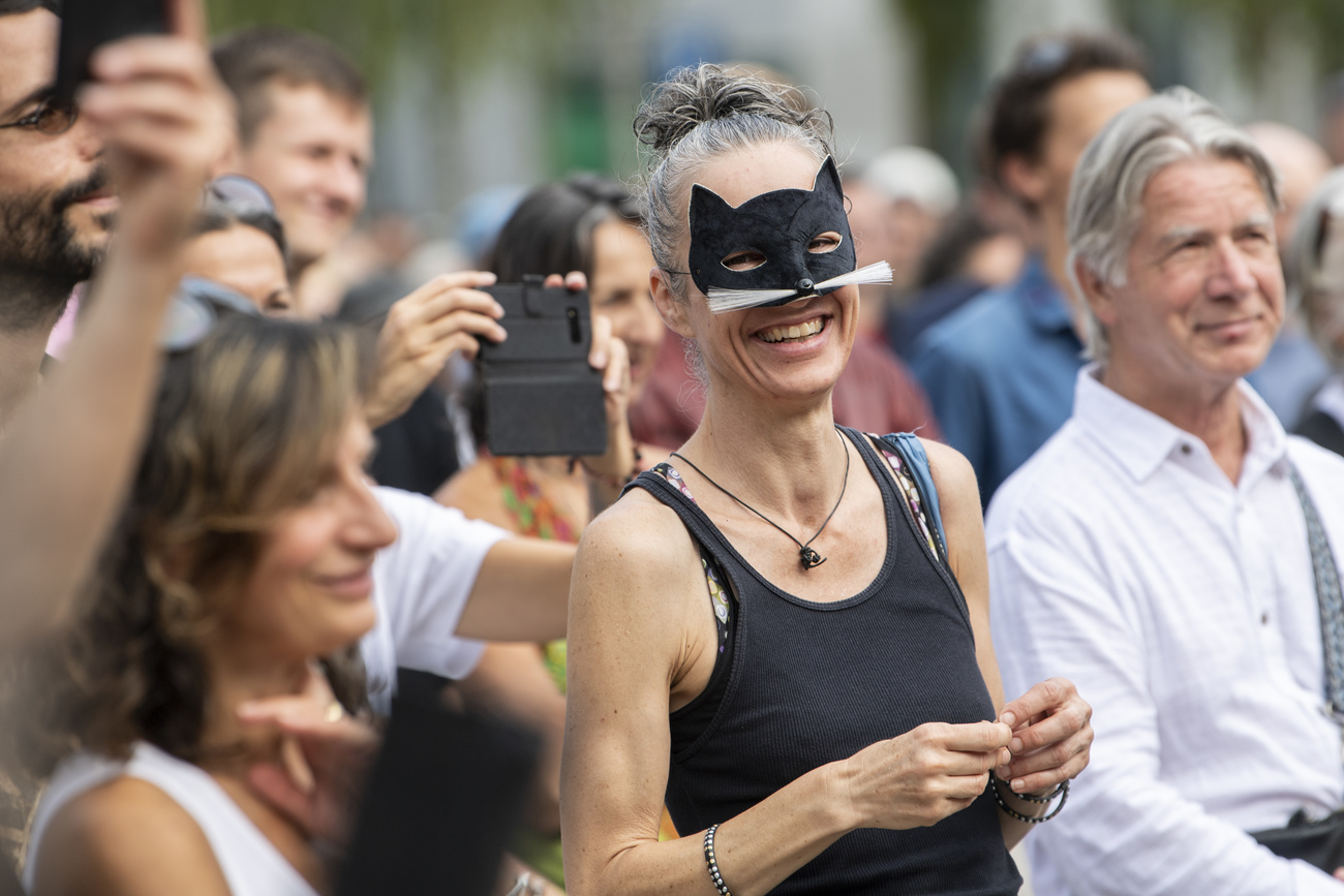 Gruppo di perse in piazza, una indossa una mascherina da carnevale con orecchie e vibrisse da gatto