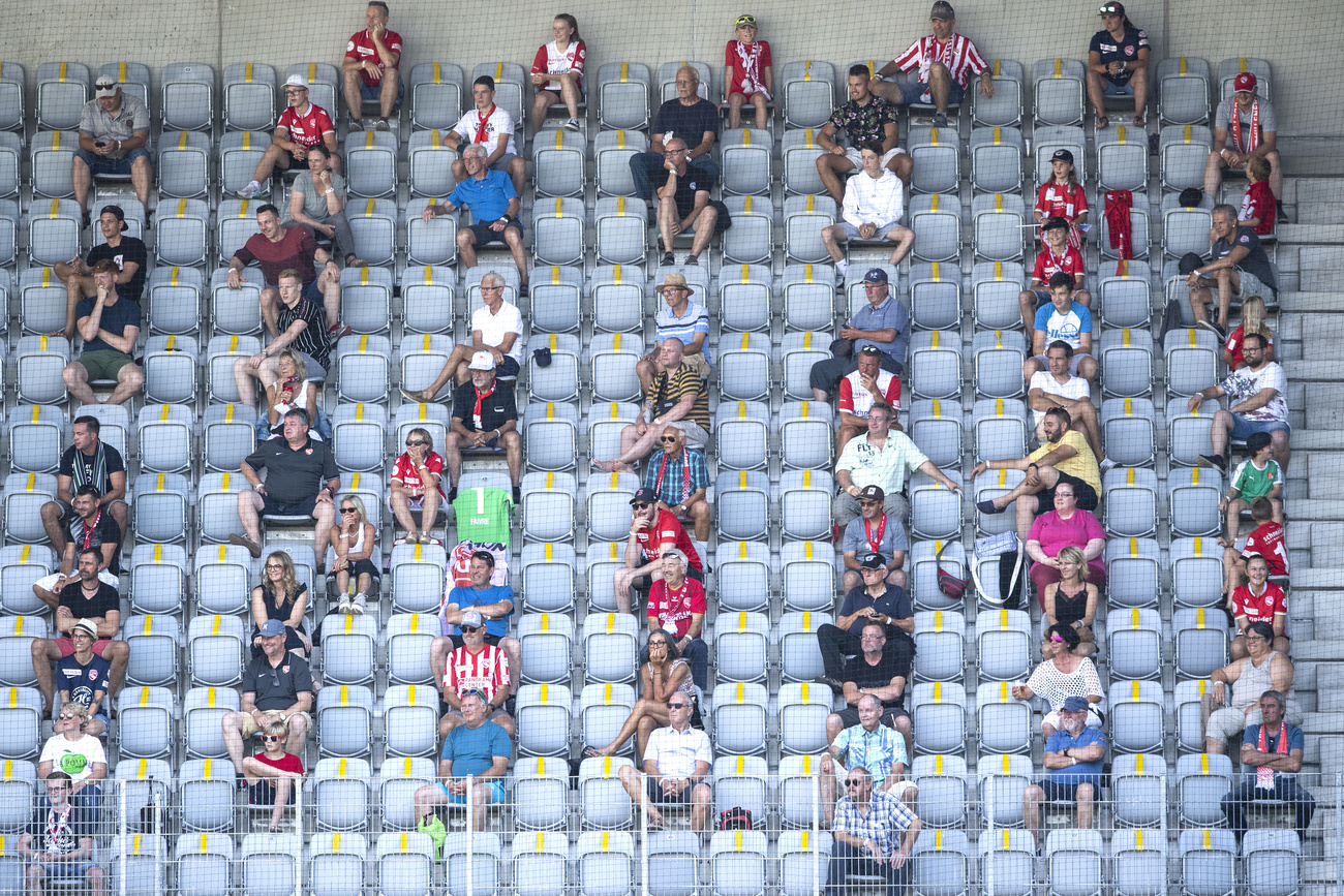 Spectactors at a football match sitting apart