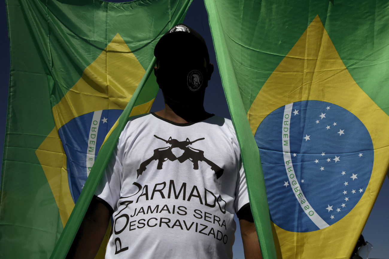 una persona tra due bandiere brasiliane
