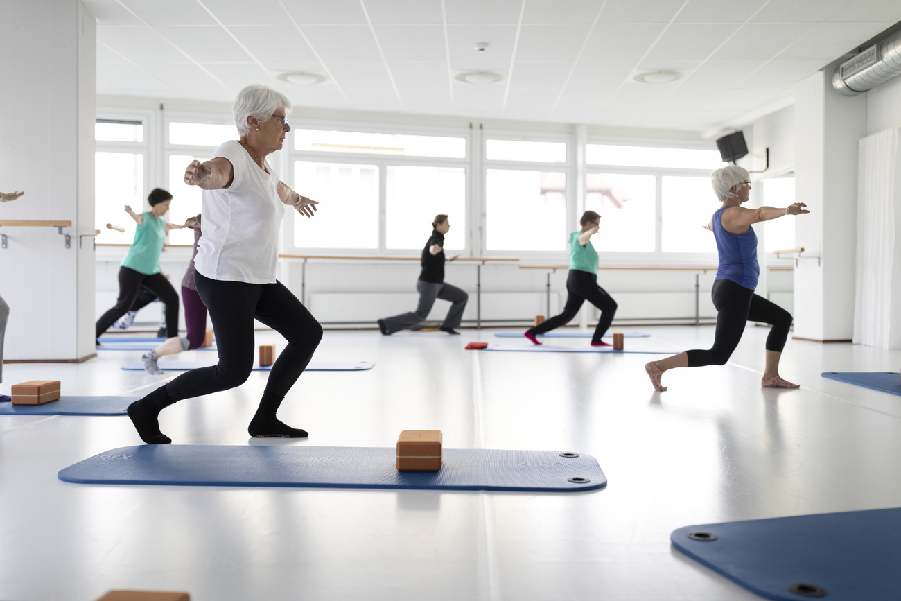 Elderly women doing exercise in a room.