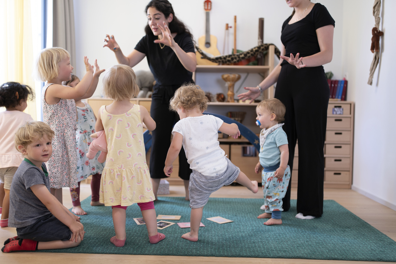 Guardería infantil: dos cuidadoras con un grupo de niños