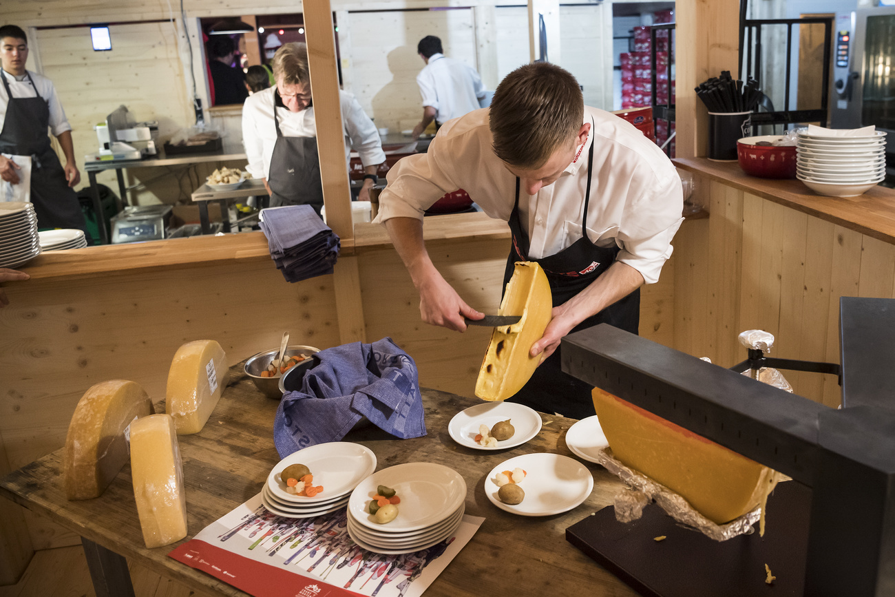 Un uomo prepara la tipica raclette.