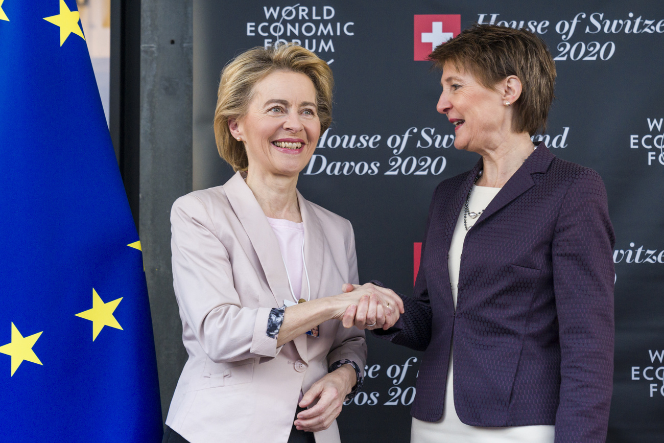 Ursula von der Leyen e Simonetta Sommaruga in piedi si stringono la mano.