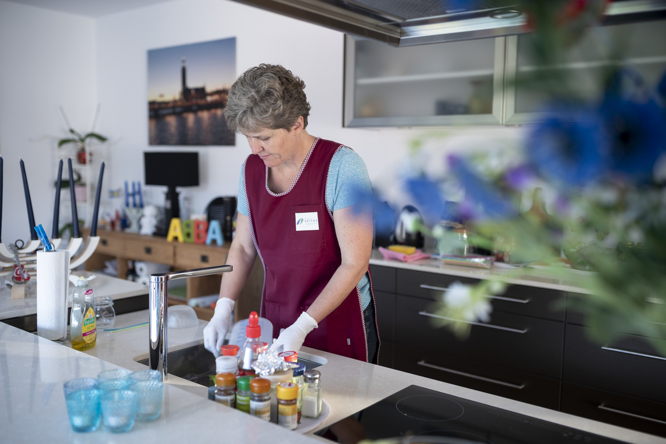 Femme faisant la vaisselle dans une cuisine.