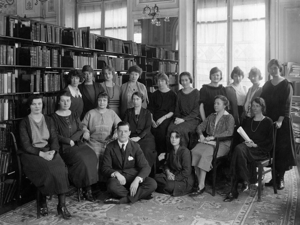 مجموعة من النساء في صورة تذكارية أمام رفوف مكتبة