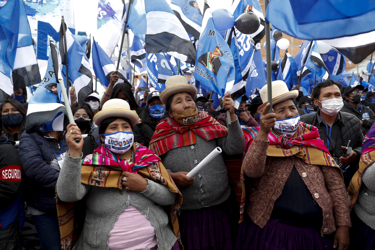 Manifestation en Bolivie avec des femmes masquées et portant des drapeaux.