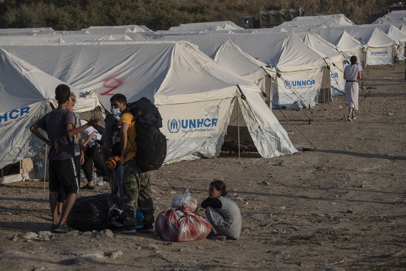 people talking in front of a tent