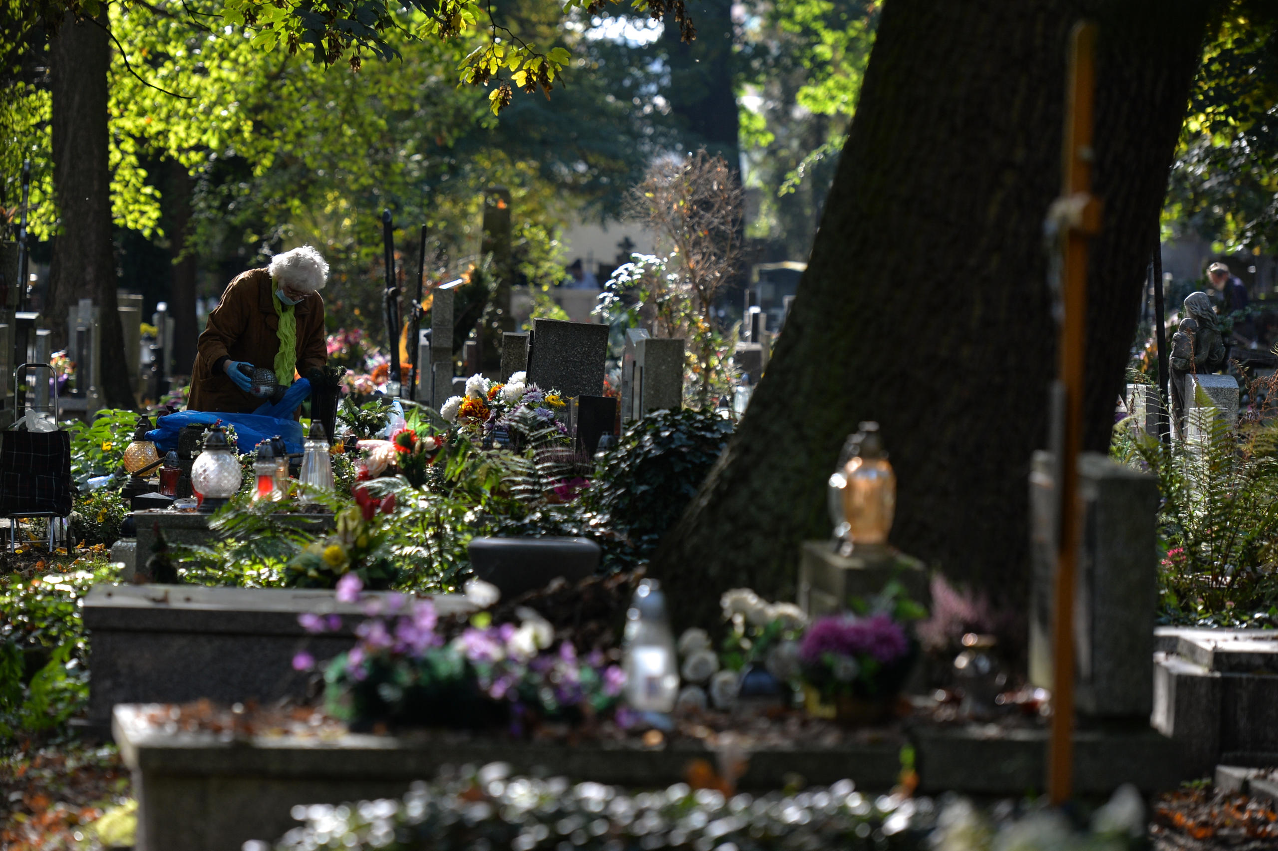 una donna deposita dei fiori su una tomba
