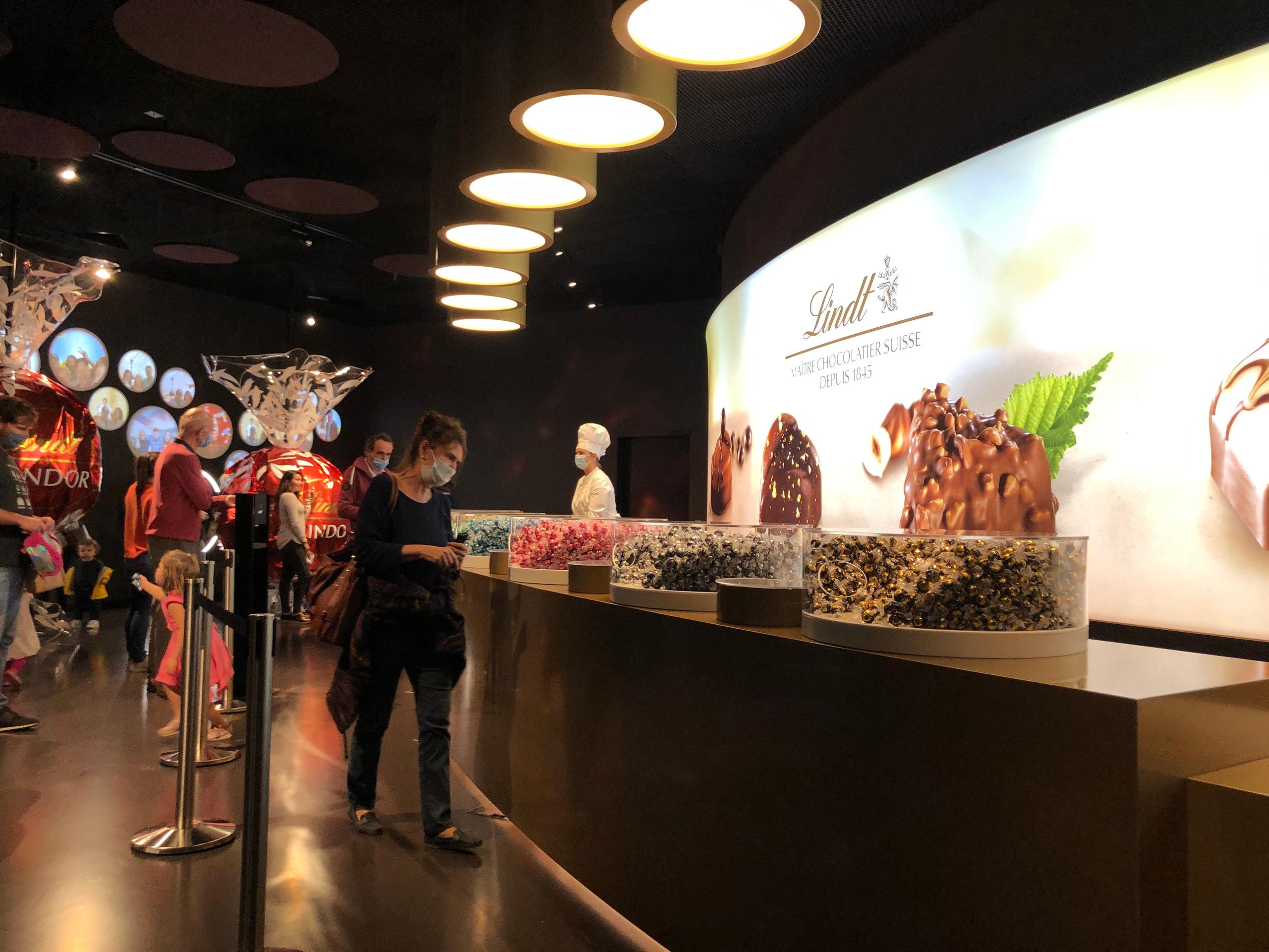 Personas toman chocolates instalados en un mostrador