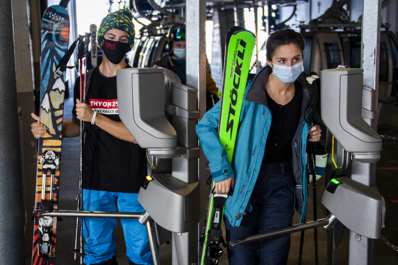 マスクをしてスキー板を抱えた人々
