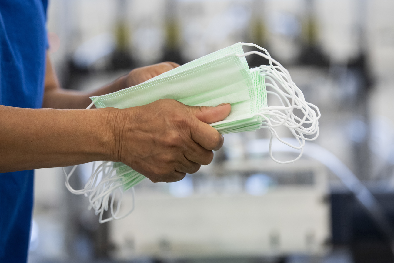 A man holding a pile of surgical masks