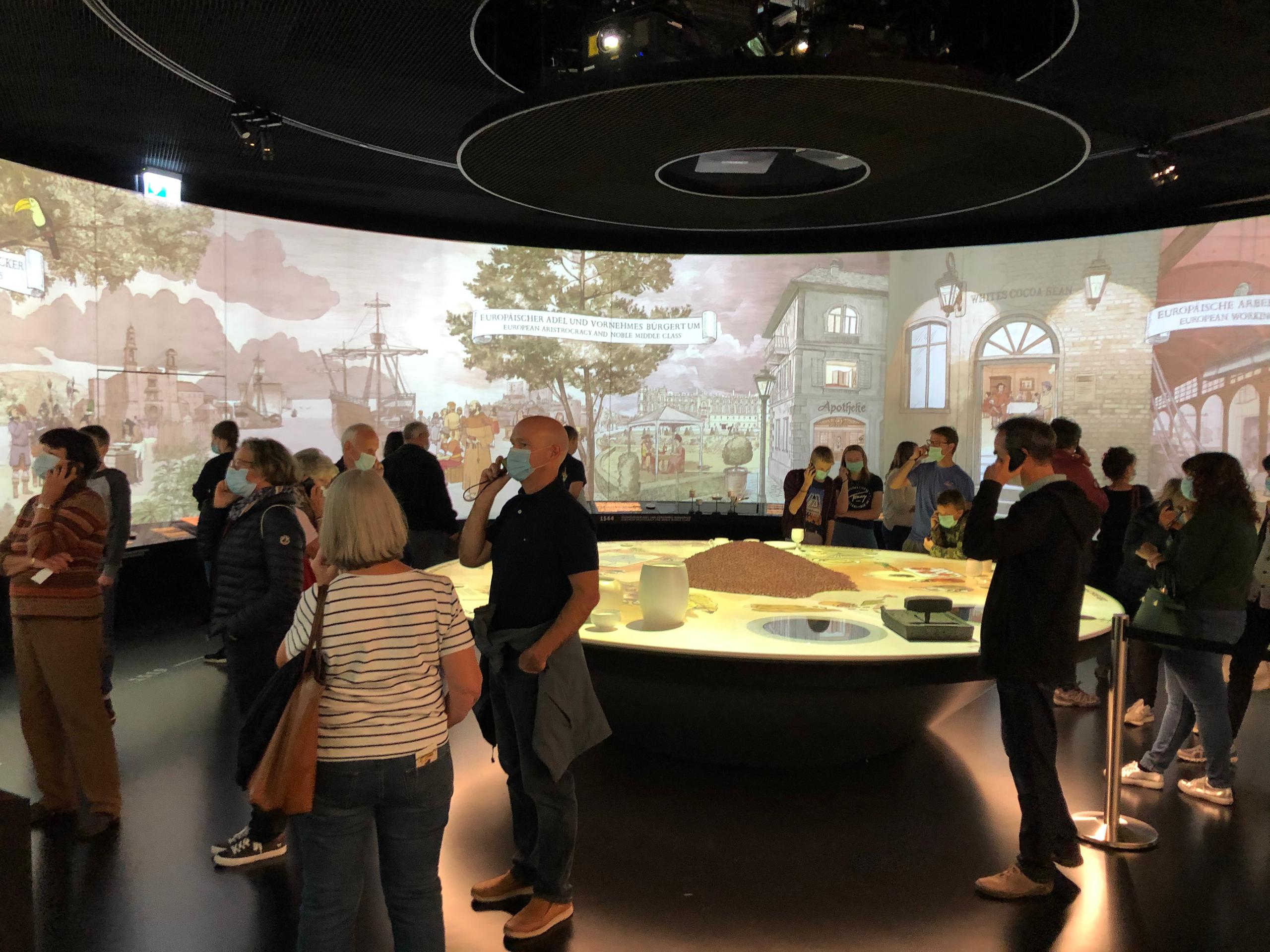 Personas en sala del museo ven videos