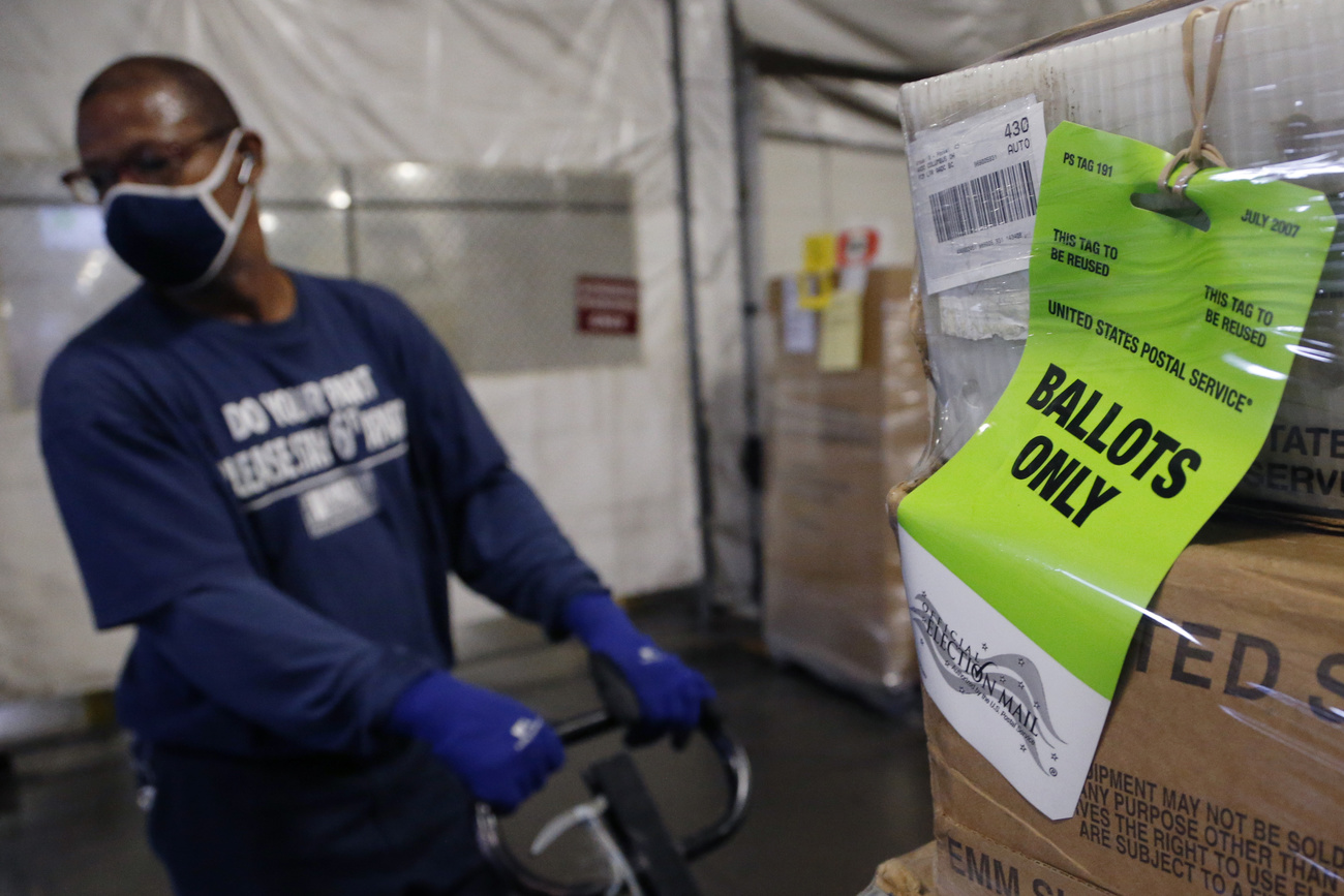 Un empleado postal transporta cajas con documentación electoral