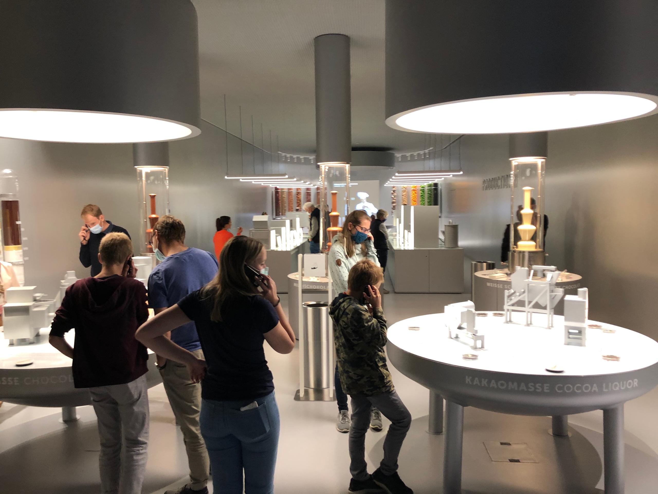 Pessoas em uma sala com fones de ouvido e fontes de chocolate ao fundo