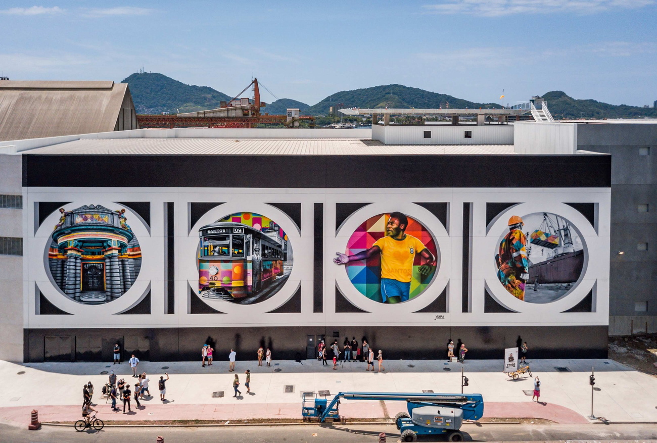 Facciata di edificio di industriale decorato con 4 grandi murales circolari di cui uno raffigura Pelé