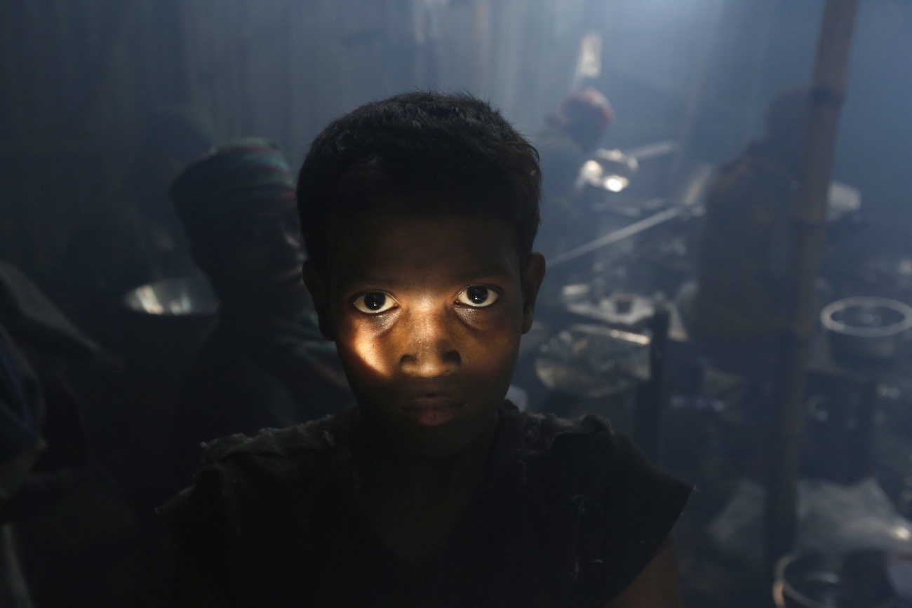 طفل عامل في بنغلاديش يقف أثناء استراحة