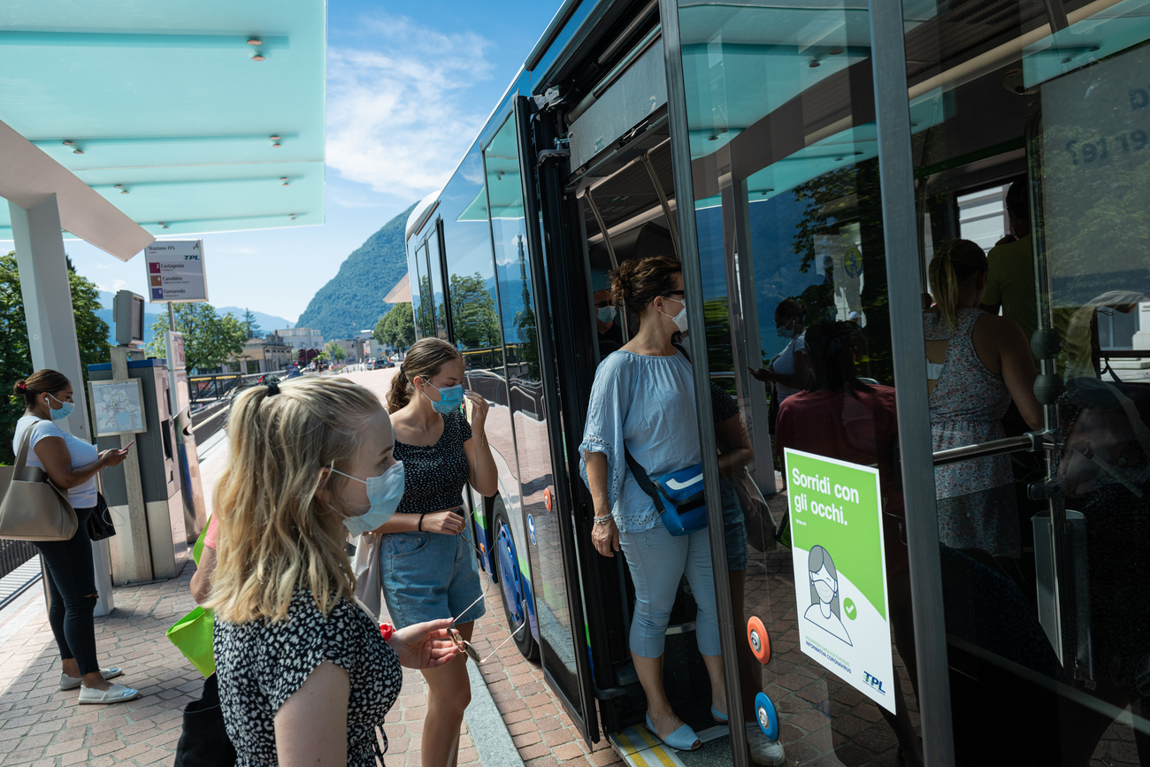 Ragazze salgono sul bus con la mascherina