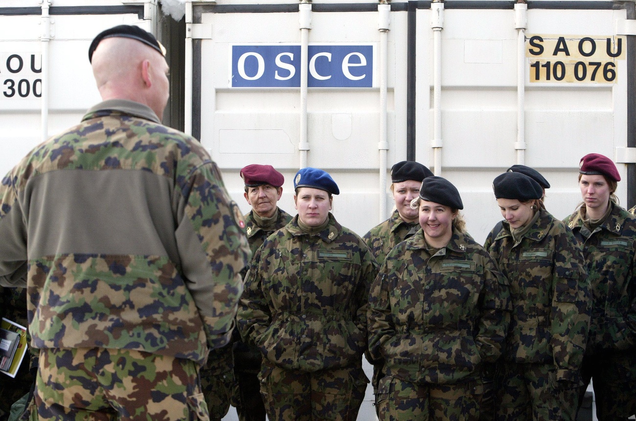 Female member of the Swiss armed forces in front of OSCE container