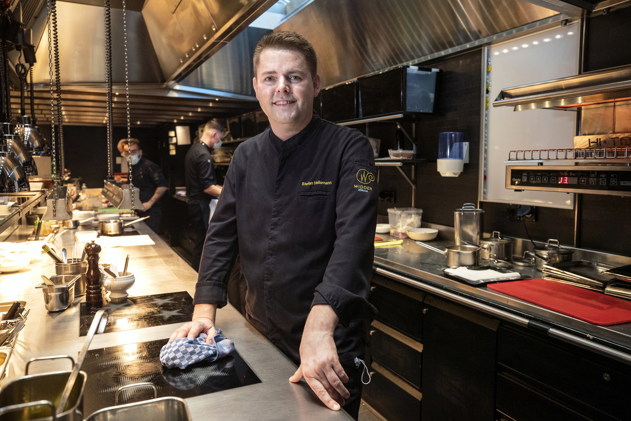 Man in a kitchen polishing the stove