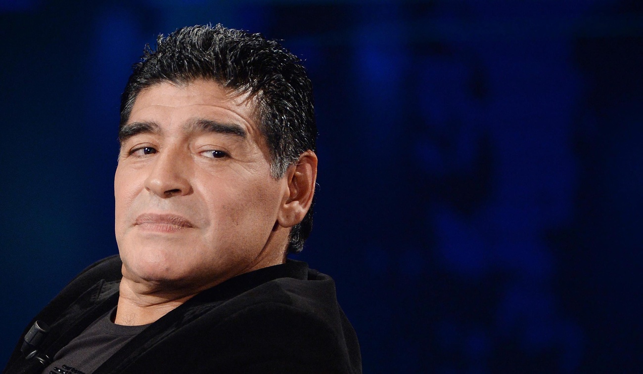 Primo piano di Maradona che guarda qualcuno di lato; sfondo blu scuro