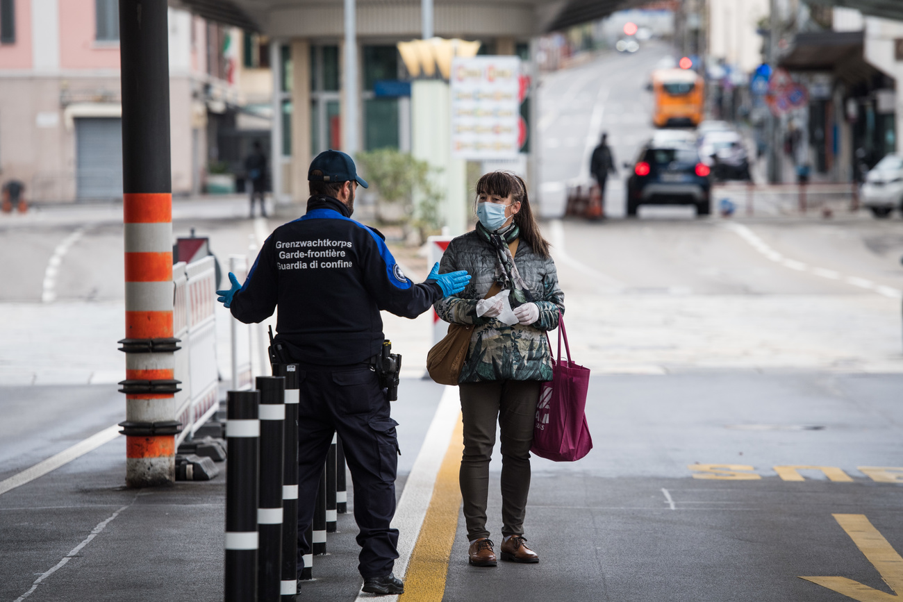 Una donna a piedi viene fermata al valico doganale di Chiasso.