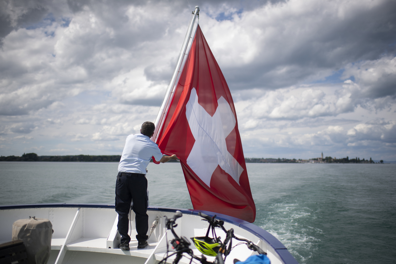 Una bandiera svizzera issata dietro a un battello turistico.