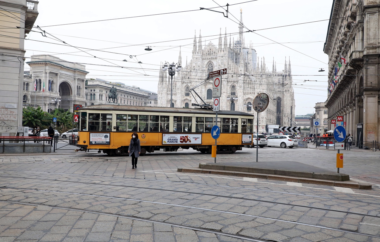 Un tram passa davanti a Piazza del Duomo a Milano.