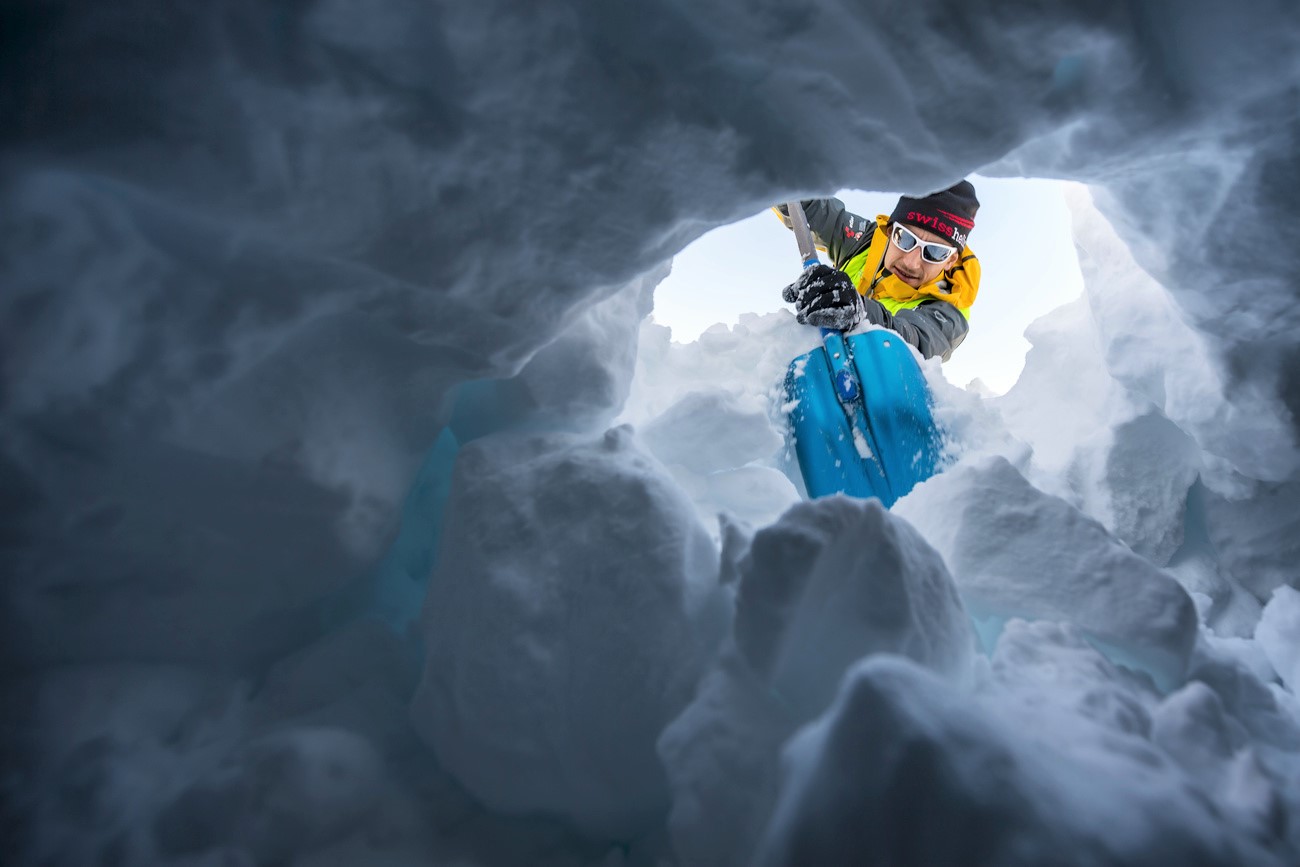 uomo scava nella neve con una pala