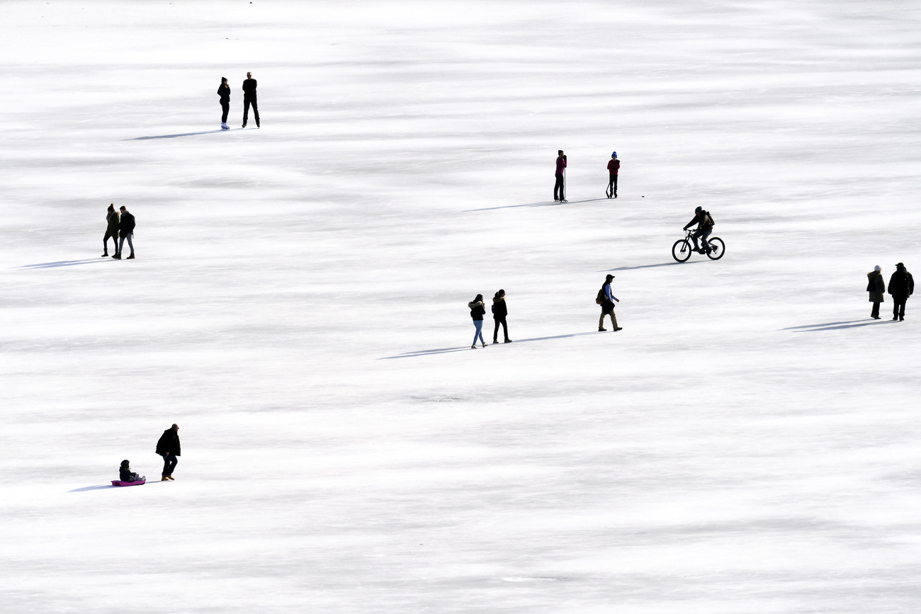 أناس يستمتعون بالتزلج والمشي على سطح البحيرة السوداء المتجمدة