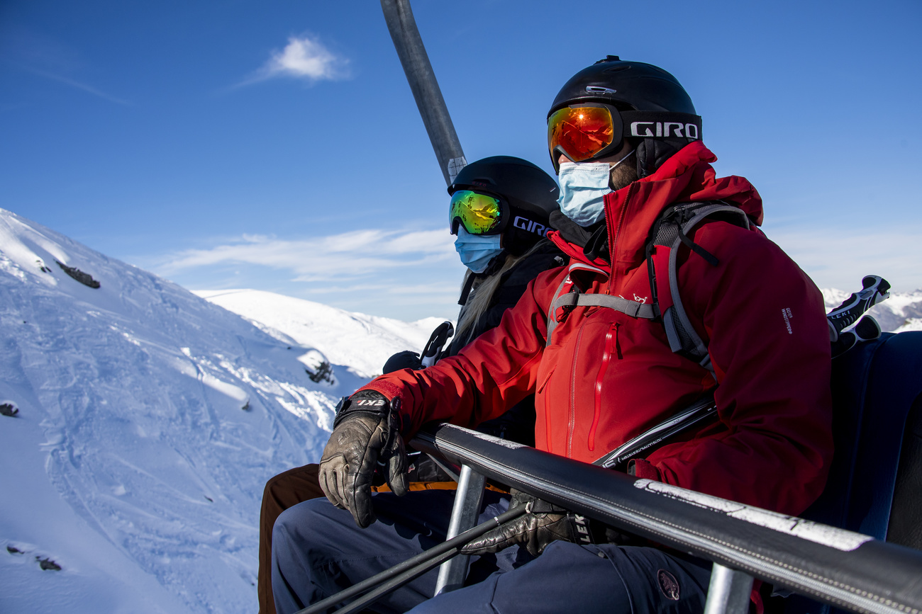 Un uomo e una donna con mascherina su una seggiovia a Verbier nel canton Vallese