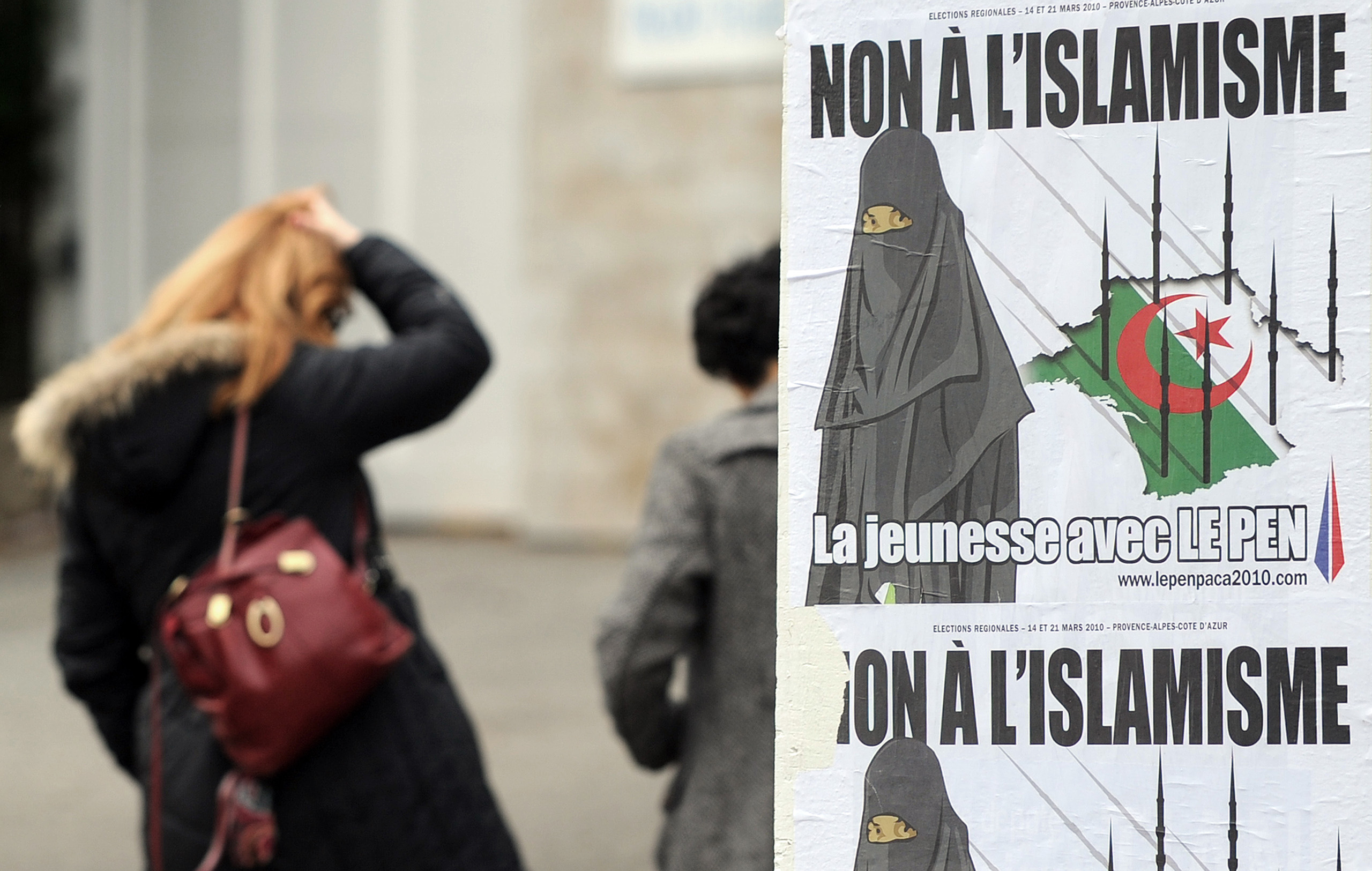Frau in Frankreich vor adaptiertem SVP Plakat