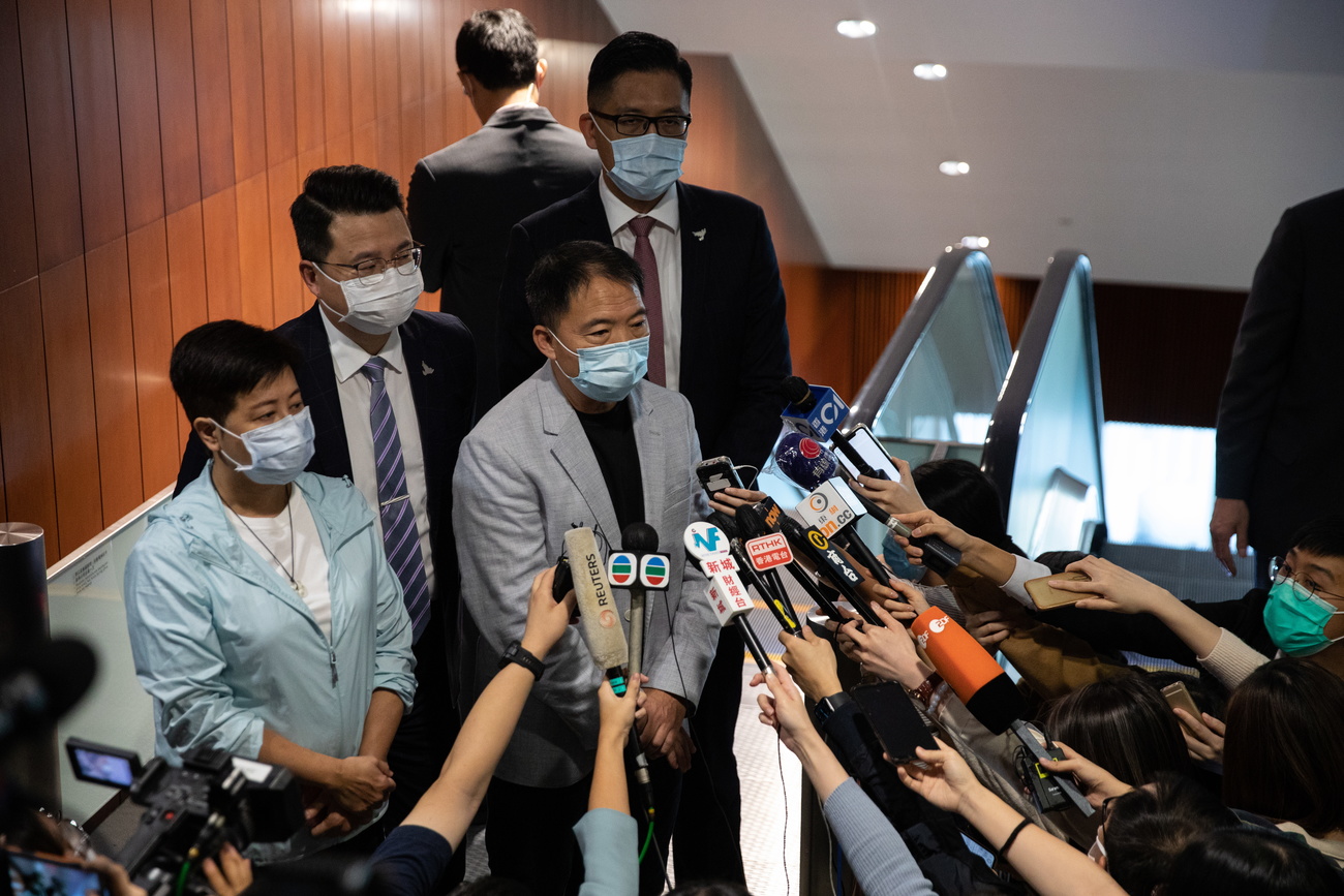 Masked people in front of reporters